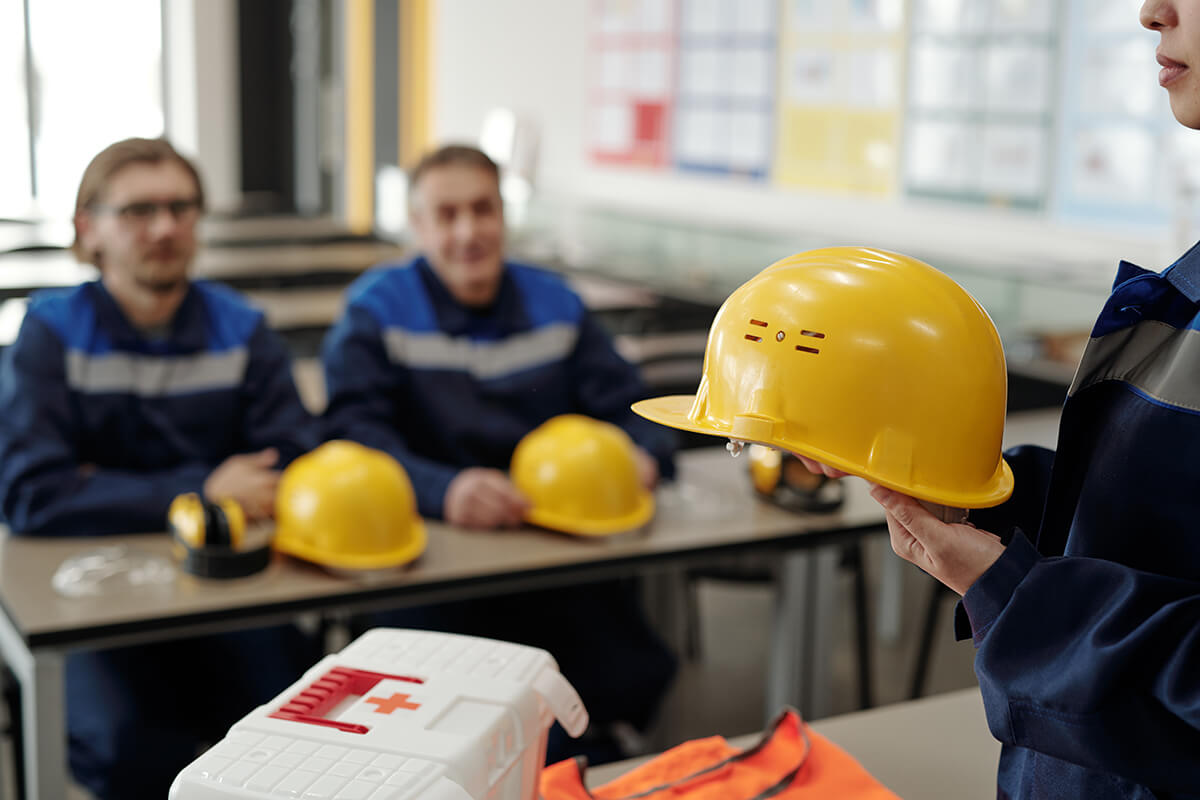 ayoung-female-worker-uniform-holding-protective-helmet-while-standing-front-male-colleagues-lesson-basics-life-safety copia (1)